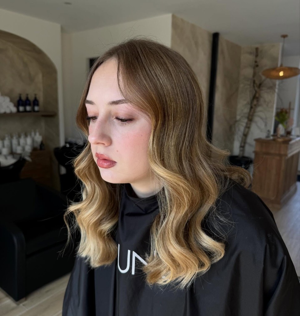 Coiffage blond avec ondulations souples en salon.